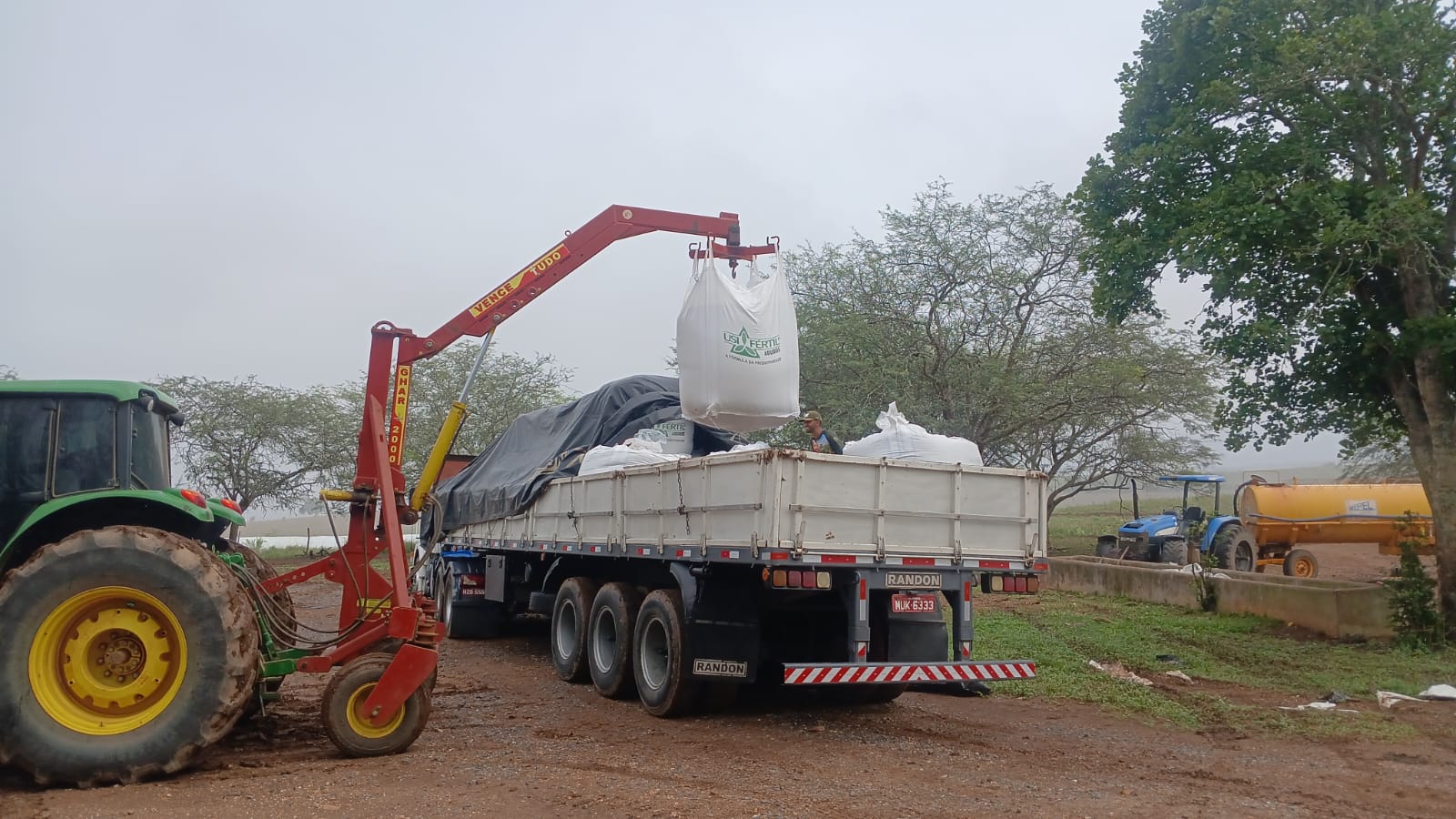 Caminhão da FertBrasil carregando big bags de fertilizante com guindaste munck